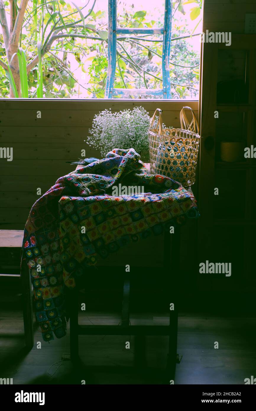 Klassischer Stil mit handgefertigtem Produkttropfen vom Holztisch mit Fensterlicht, Decke diy aus Häkelstücken, winziger Blumentopf, Bambushandtasche, Treppe Stockfoto