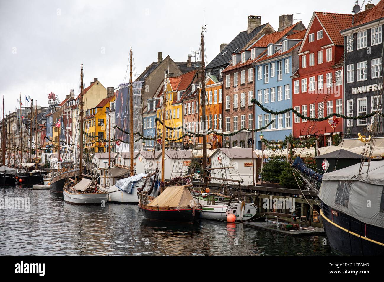 Vertäute Segelboote und farbenfrohe Gebäude an einem grauen Dezembertag im Stadtteil Nyhavn in Kopenhagen, Dänemark Stockfoto