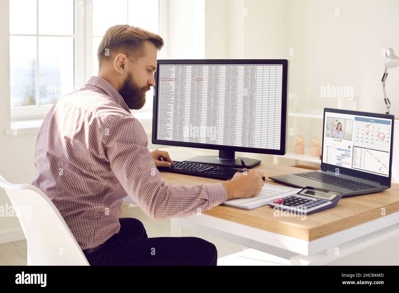Buchhalter Multitasking während der Arbeit mit Daten auf Computern an seinem Schreibtisch im Büro Stockfoto