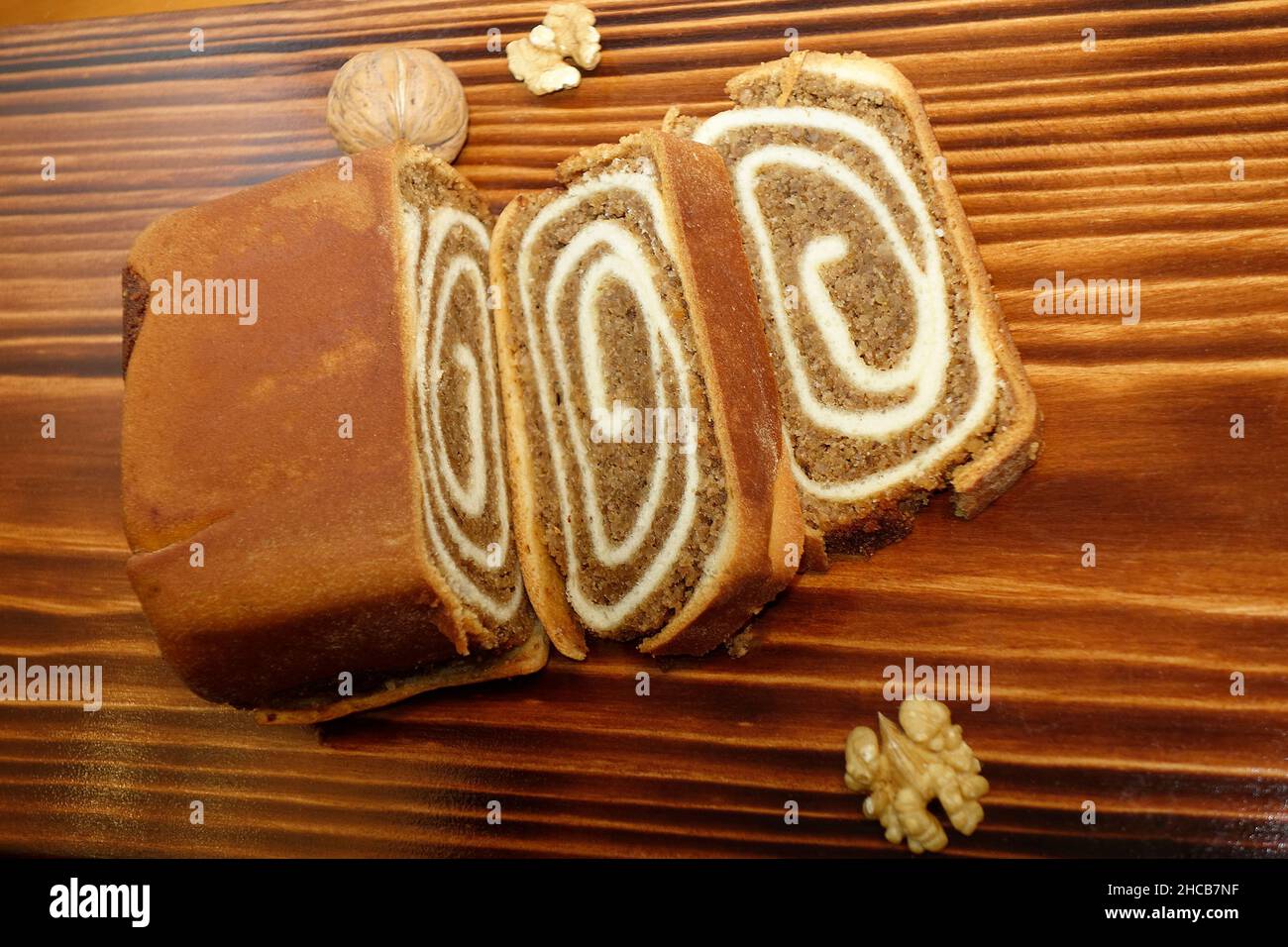 Nussbaum-Pastry 'Potica' auf verkohltem Holz Hintergrund. In Slowenien ist dieser Kuchen so traditionell, dass er Teil der nationalen Identität ist Stockfoto
