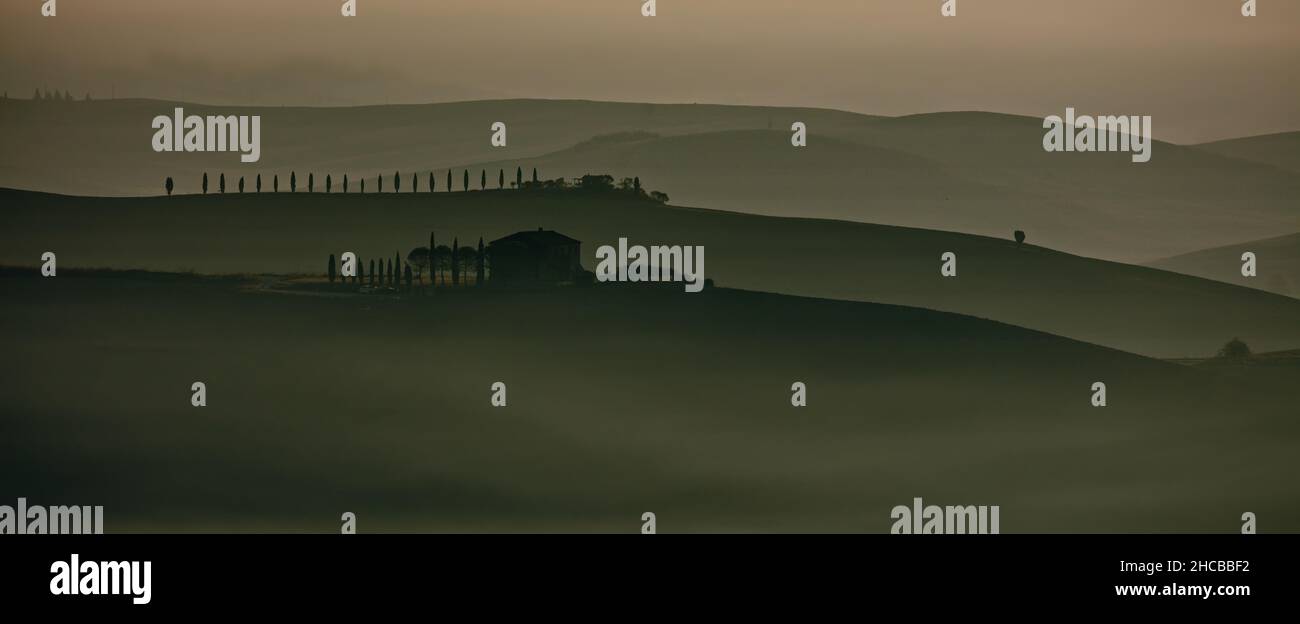 Silhouette von grünen Hügeln mit Bäumen und auf dem Hintergrund in Toscana, Italien Stockfoto