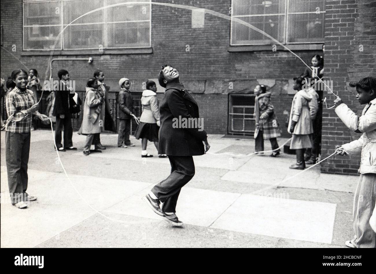 Ein junges Mädchen macht Double Dutch Springseil in einem Schulhof in Brooklyn, New York im Jahr 1981. Stockfoto