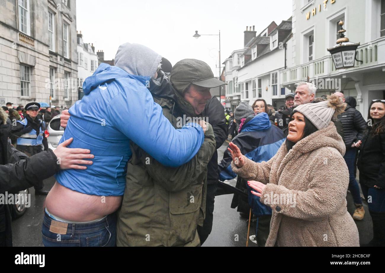 Lewes UK 27th December 2021 - Ein Profi-Hunt-Unterstützer (links) versucht, sich bei der Southdown and Eridge Hunt Parade durch das Stadtzentrum von Lewes am Weihnachtsfeiertag in Großbritannien ein Banner für die Jagd zu sichern : Credit Simon Dack / Alamy Live News Stockfoto