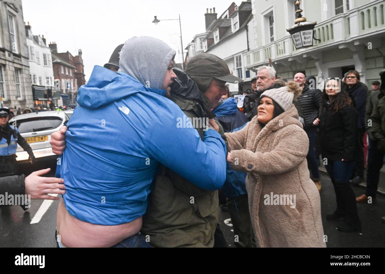 Lewes UK 27th December 2021 - Ein Profi-Hunt-Unterstützer (links) versucht, sich bei der Southdown and Eridge Hunt Parade durch das Stadtzentrum von Lewes am Weihnachtsfeiertag in Großbritannien ein Banner für die Jagd zu sichern : Credit Simon Dack / Alamy Live News Stockfoto