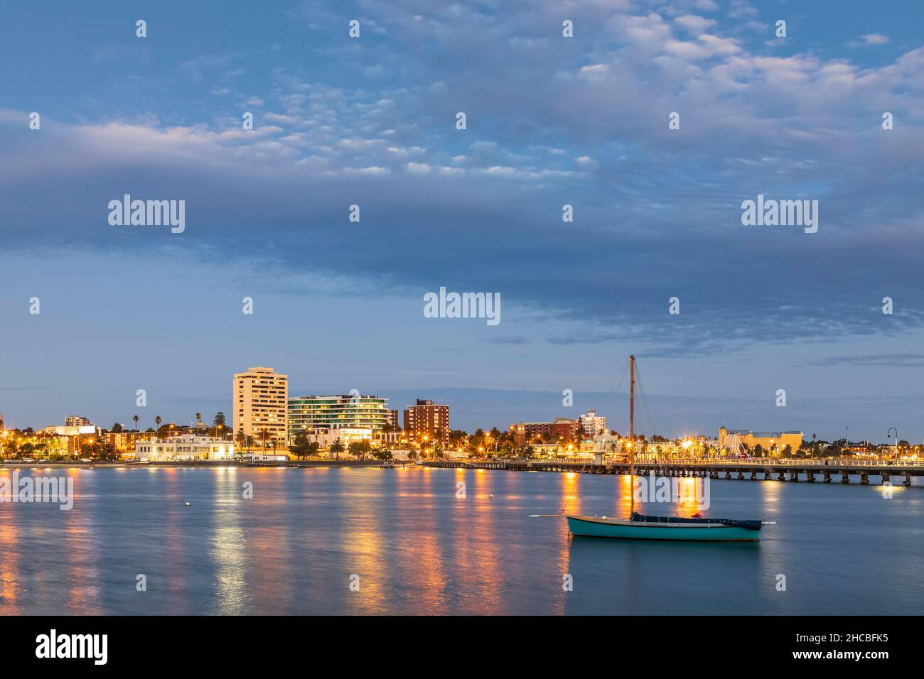 Australien, Victoria, Melbourne, Port Philip Bay in der Sommerdämmerung mit Skyline im Hintergrund Stockfoto