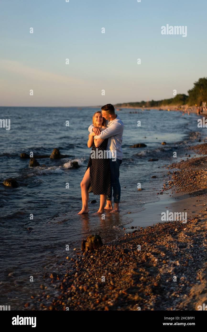 Mann umarmt Frau am Strand Stockfoto