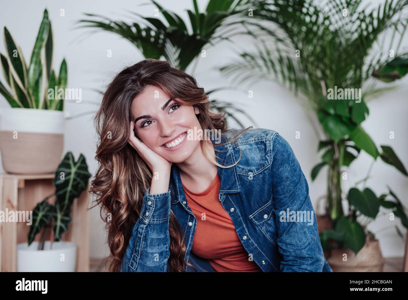 Junge Frau mit langen Haaren Tag träumen im Wohnzimmer Stockfoto