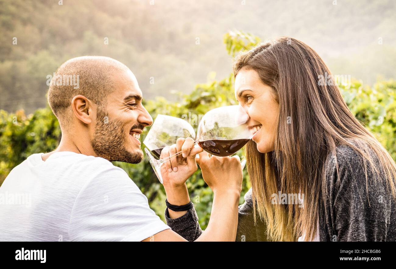 Glückliches junges Paar Liebhaber trinken Rotwein im Weingut Bauernhaus - schöner Mann Blick auf schöne Frau Augen - Alternative Beziehung Konzept Stockfoto