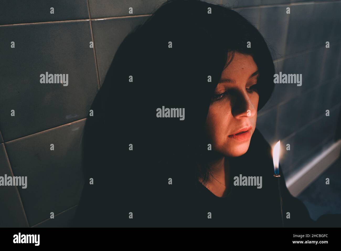 Einsame Frau, die auf brennende Flamme schaut Stockfoto