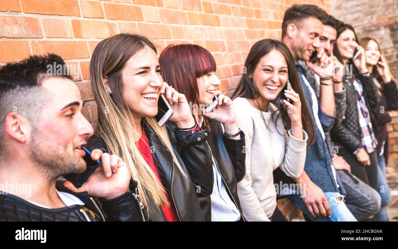 Millennial Jungs und Mädchen mit Handy und Spaß an Backsteinmauer in der Stadt - Urban Jugend und Technologie-Konzept Stockfoto