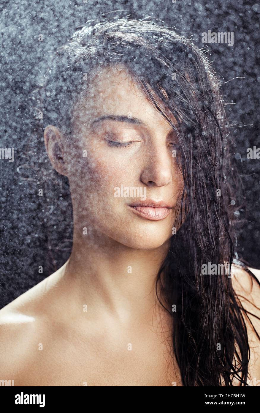 Wasser sprüht auf Frau mit geschlossenen Augen Stockfoto