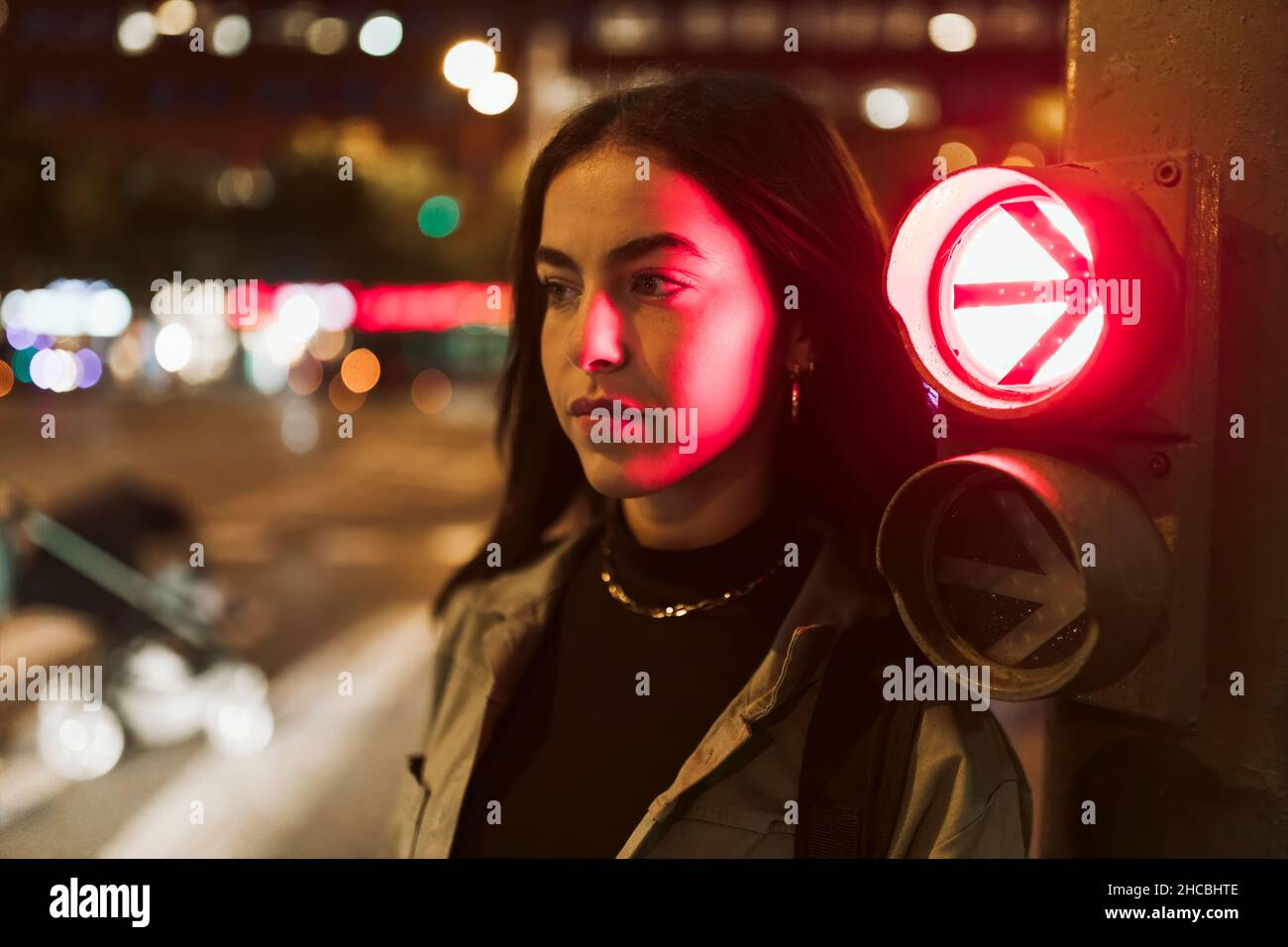 Frau am roten Verkehrspfeil in der Nacht Stockfoto