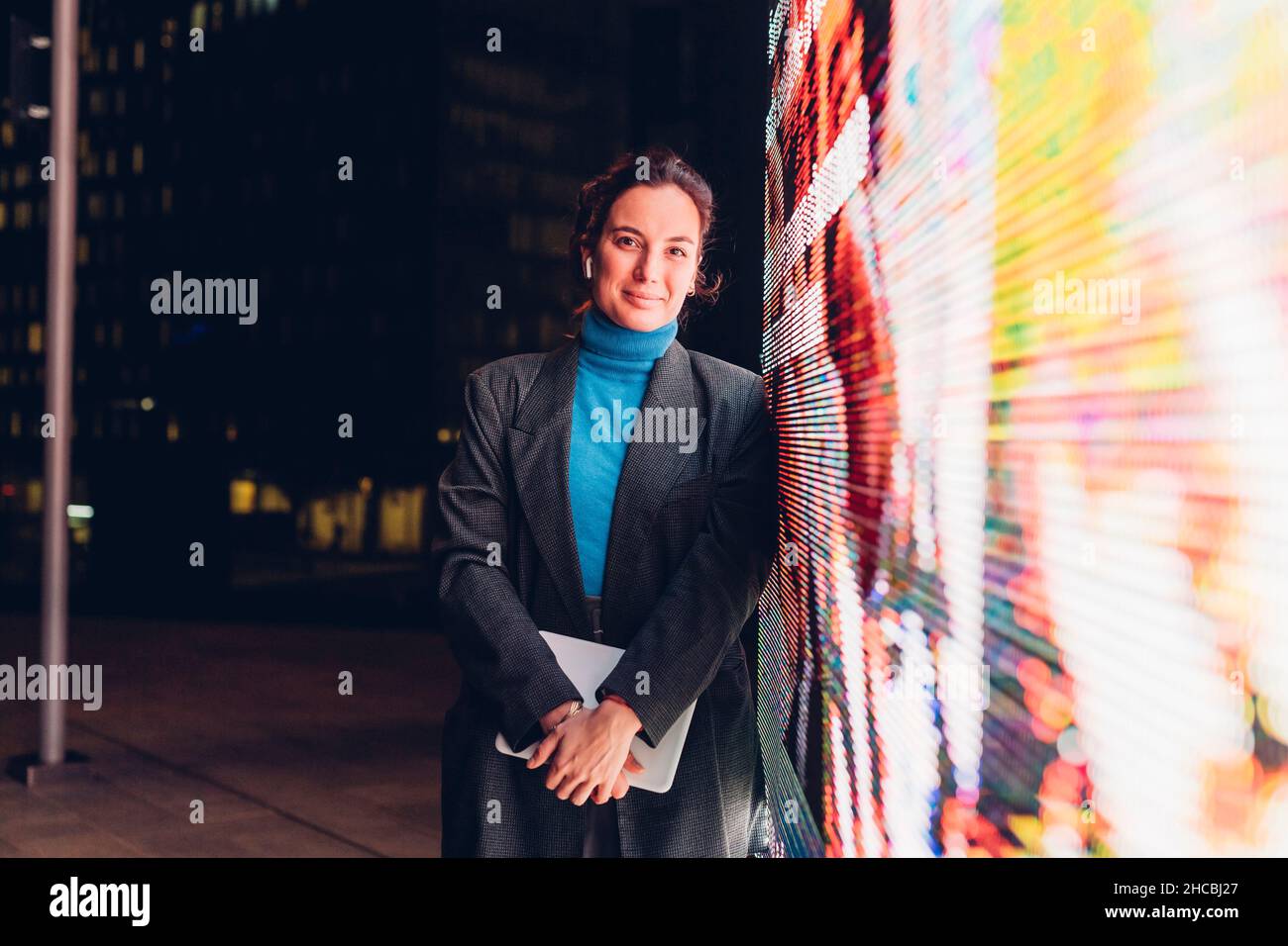 Lächelnde Geschäftsfrau mit Tablet-PC und interaktivem Informationsstand Stockfoto