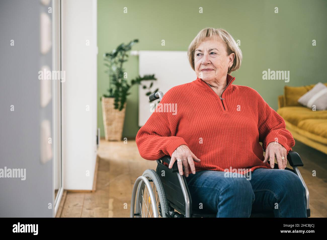 Nachdenkliche Frau mit körperlicher Behinderung im Rollstuhl Stockfoto