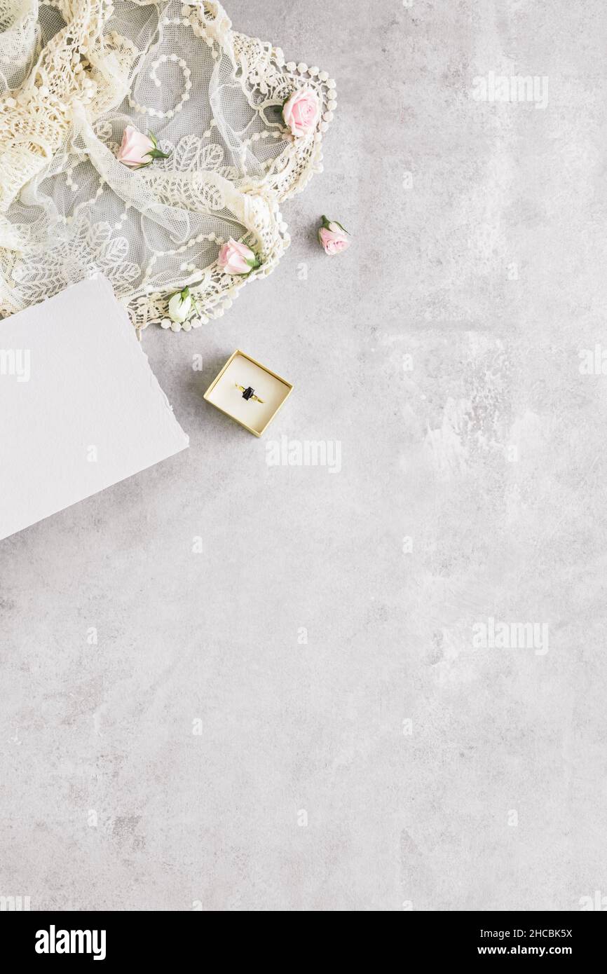 Studioaufnahme eines Paares goldener Eheringe mit Rosen im Hintergrund Stockfoto