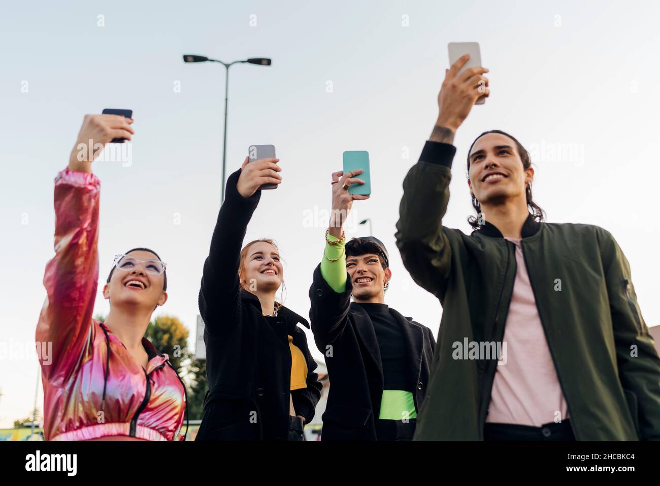 Lächelnde Freunde, die zusammen Selfies über Smartphones machen Stockfoto