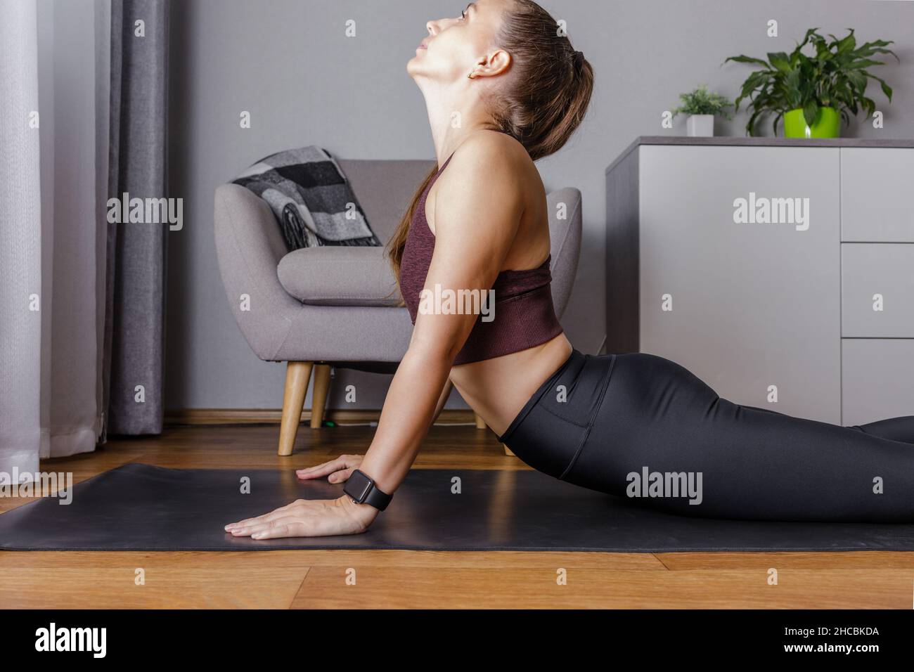 Junge Frau, die morgens zu Hause Yoga praktiziert Stockfoto