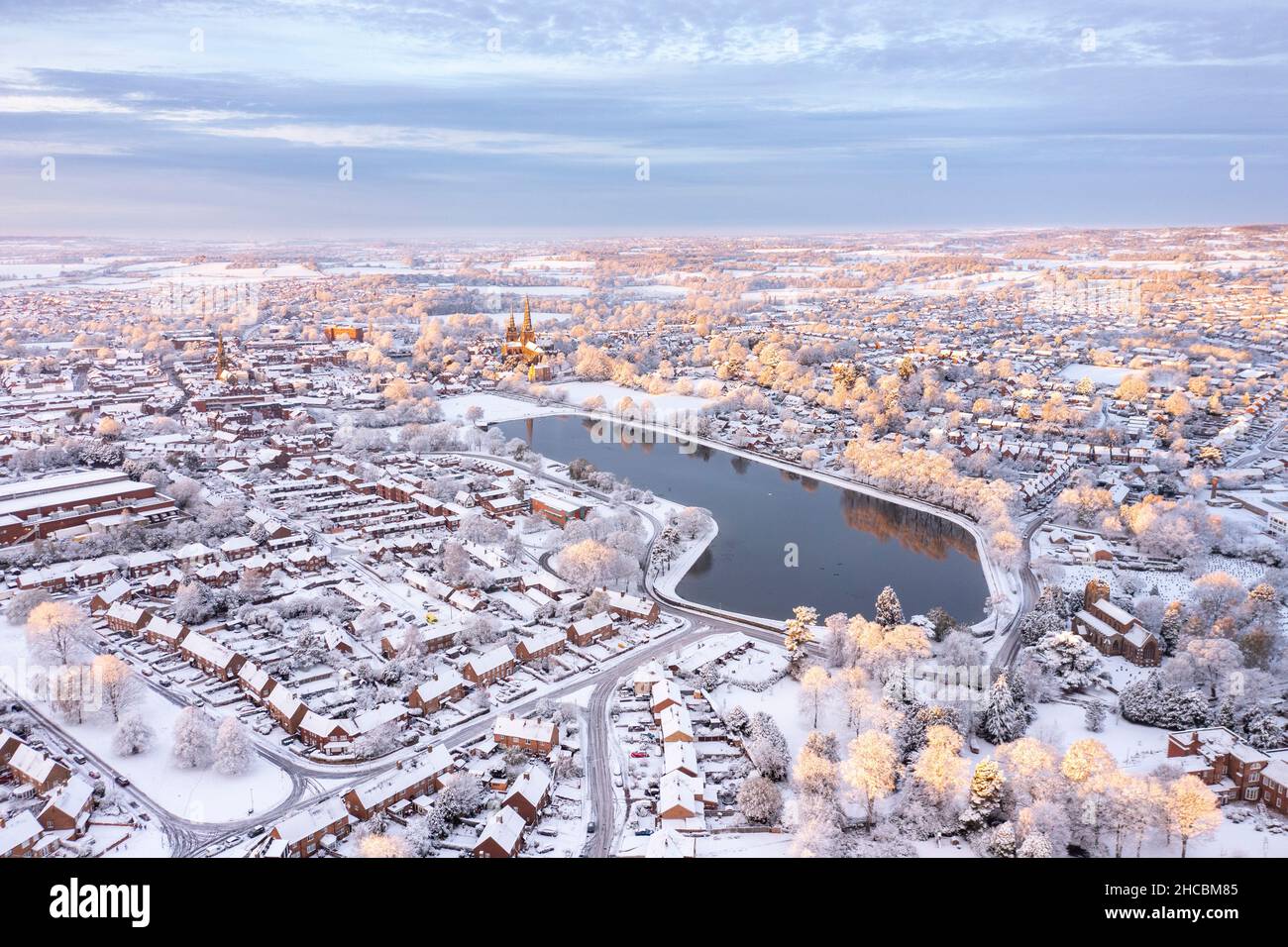 Großbritannien, England, Lichfield, Luftaufnahme des Sees in der schneebedeckten Stadt bei Dämmerung Stockfoto