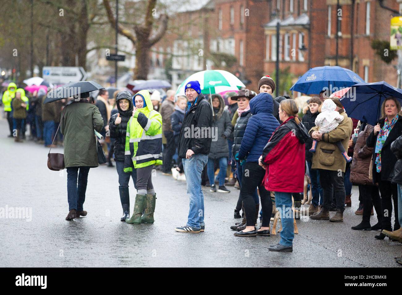 Tenterden, Kent, Großbritannien. 27. Dezember 2021. Das jährliche Treffen der Ashford Valley Tickham Hunt zum zweiten Weihnachtsfeiertag wird im Zentrum von Tenterden in Kent durchgeführt. Hunde und Pferde kommen um 11am Uhr an der Kneipe ‘The Vine Inn’ vorbei, bevor sie die Hauptstraße entlang zu einem vollen Publikum aufbrechen. Das Wetter ist nass mit Nieselregen. Foto: Paul Lawrenson/Alamy Live News Stockfoto