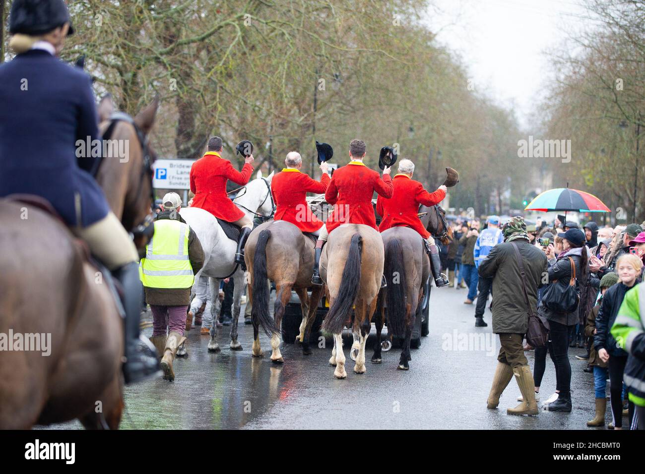 Tenterden, Kent, Großbritannien. 27. Dezember 2021. Das jährliche Treffen der Ashford Valley Tickham Hunt zum zweiten Weihnachtsfeiertag wird im Zentrum von Tenterden in Kent durchgeführt. Hunde und Pferde kommen um 11am Uhr an der Kneipe ‘The Vine Inn’ vorbei, bevor sie die Hauptstraße entlang zu einem vollen Publikum aufbrechen. Das Wetter ist nass mit Nieselregen. Foto: Paul Lawrenson/Alamy Live News Stockfoto