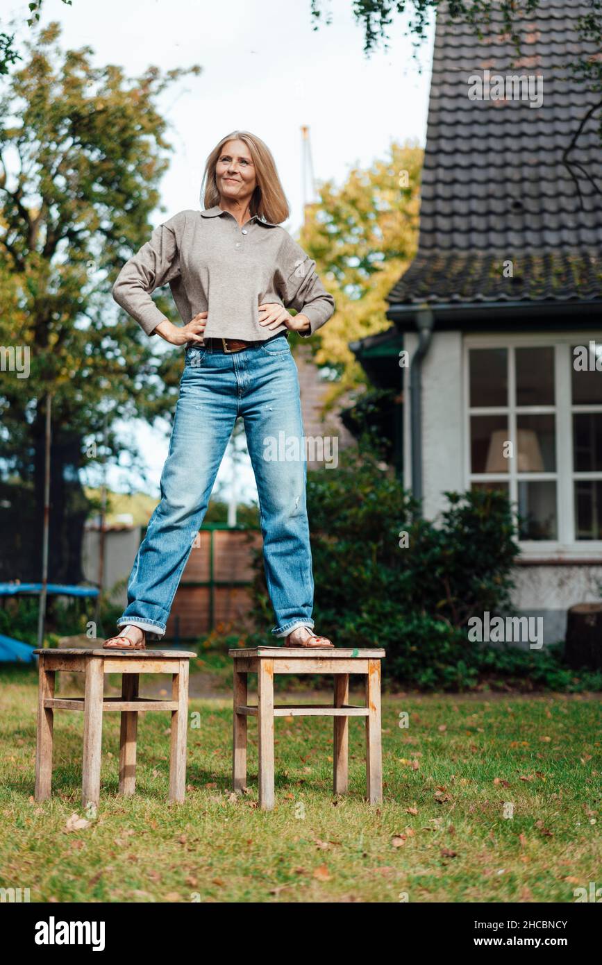 Blonde Frau mit der Hand am Kinn im Hinterhof Stockfoto