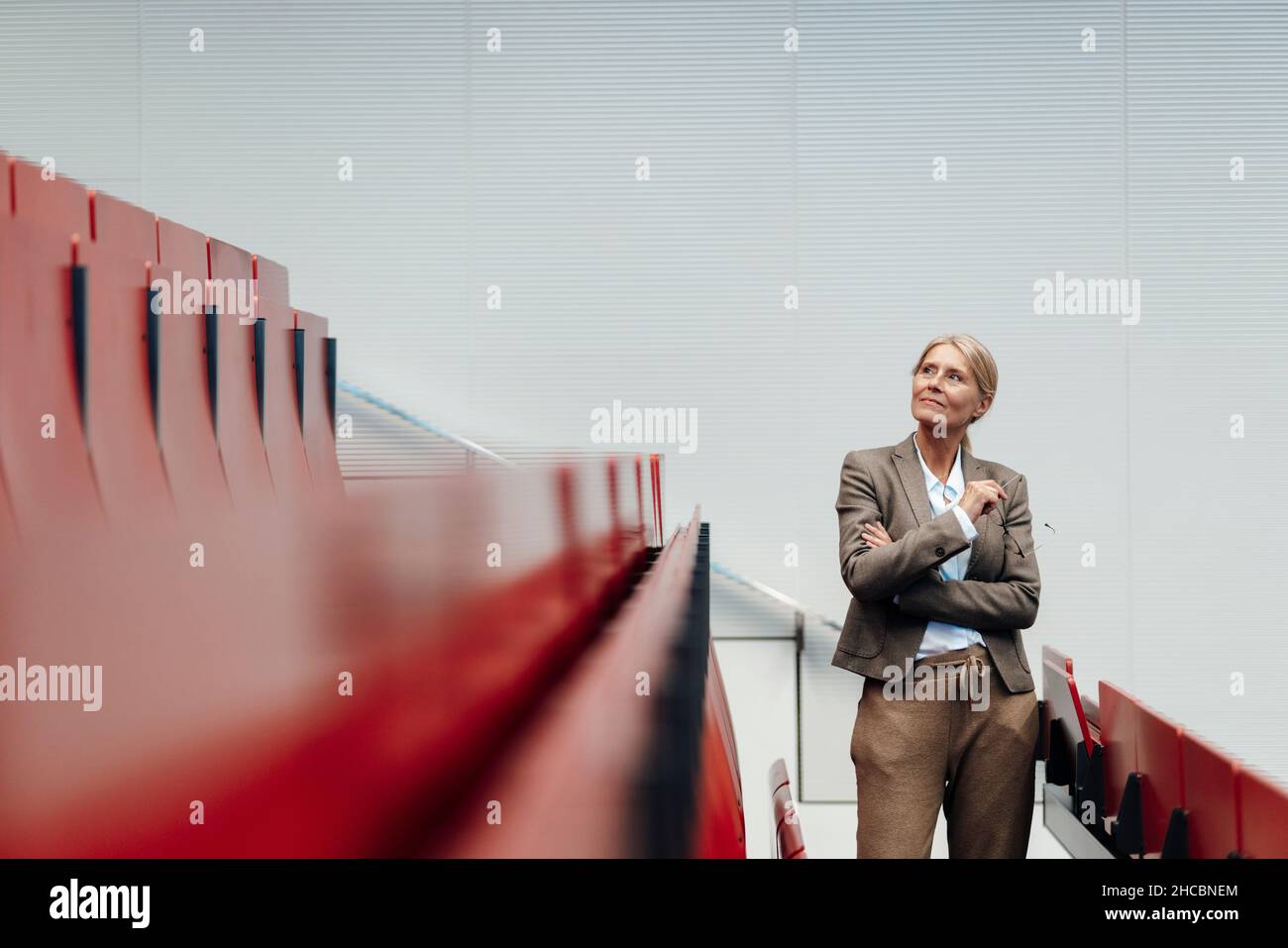 Lächelnde Geschäftsfrau im Zuschauerraum sitzt Reihe Stockfoto