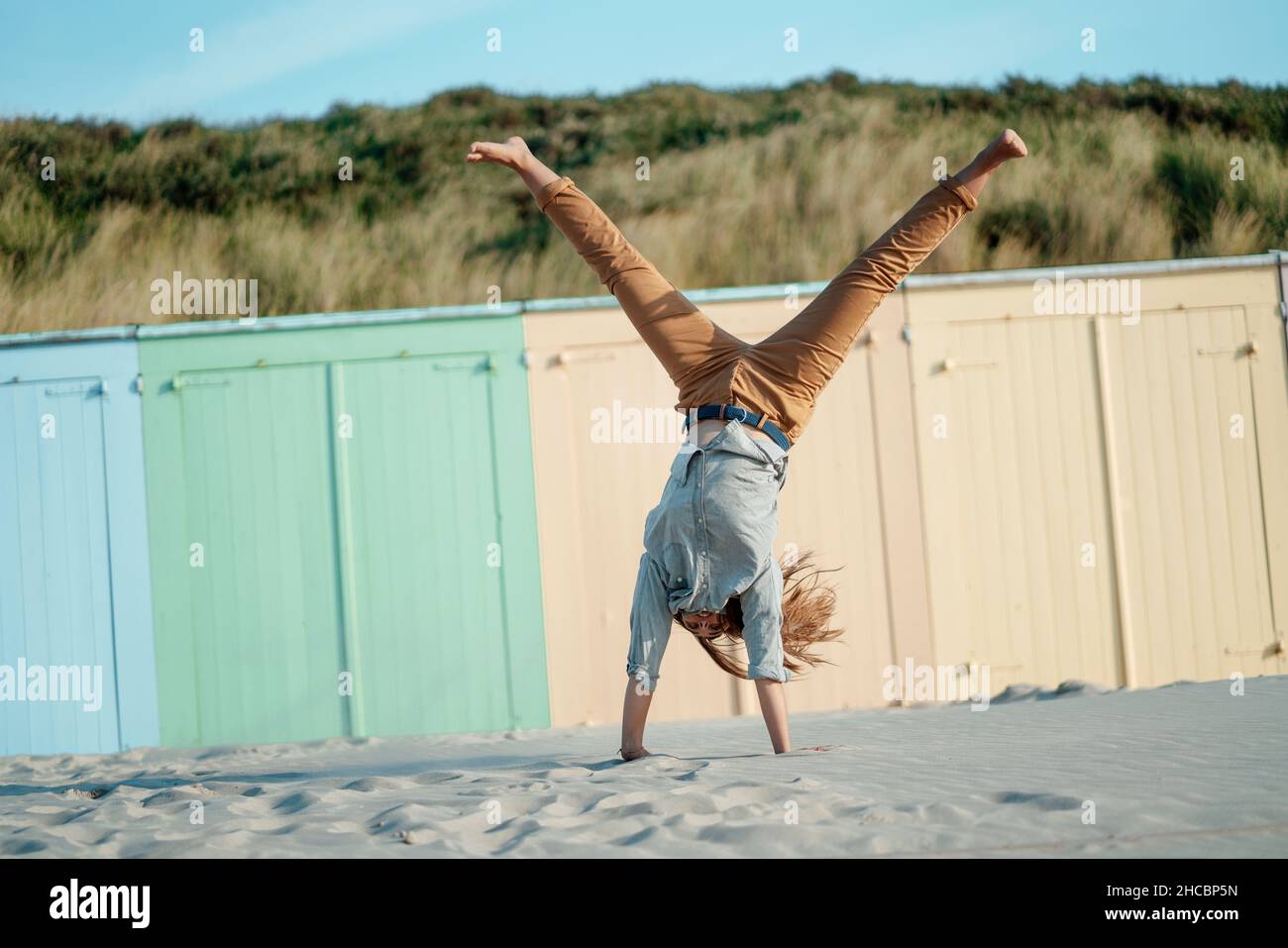 Frau, die das Auge mit Stein an der blauen Tür bedeckt Stockfoto