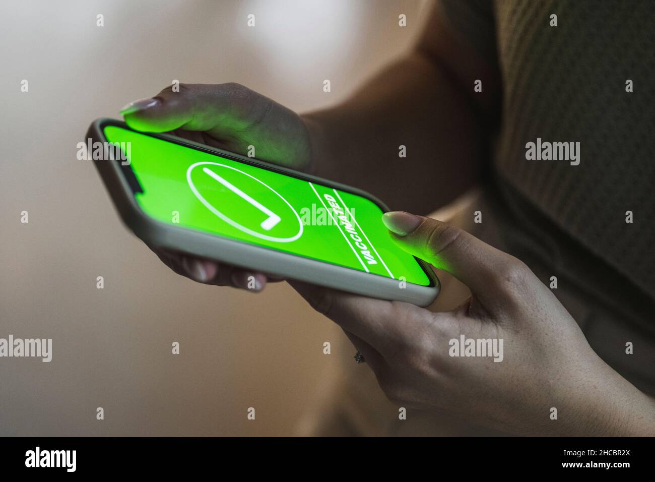 Frau mit Smartphone und grünem Häkchen auf dem Bildschirm Stockfoto