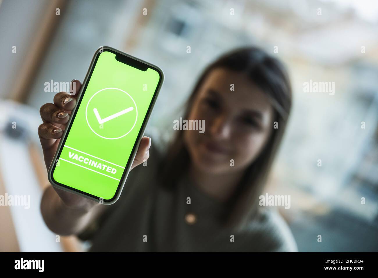 Frau, die auf dem Handy-Bildschirm ein Häkchen für die Impfung zeigt Stockfoto