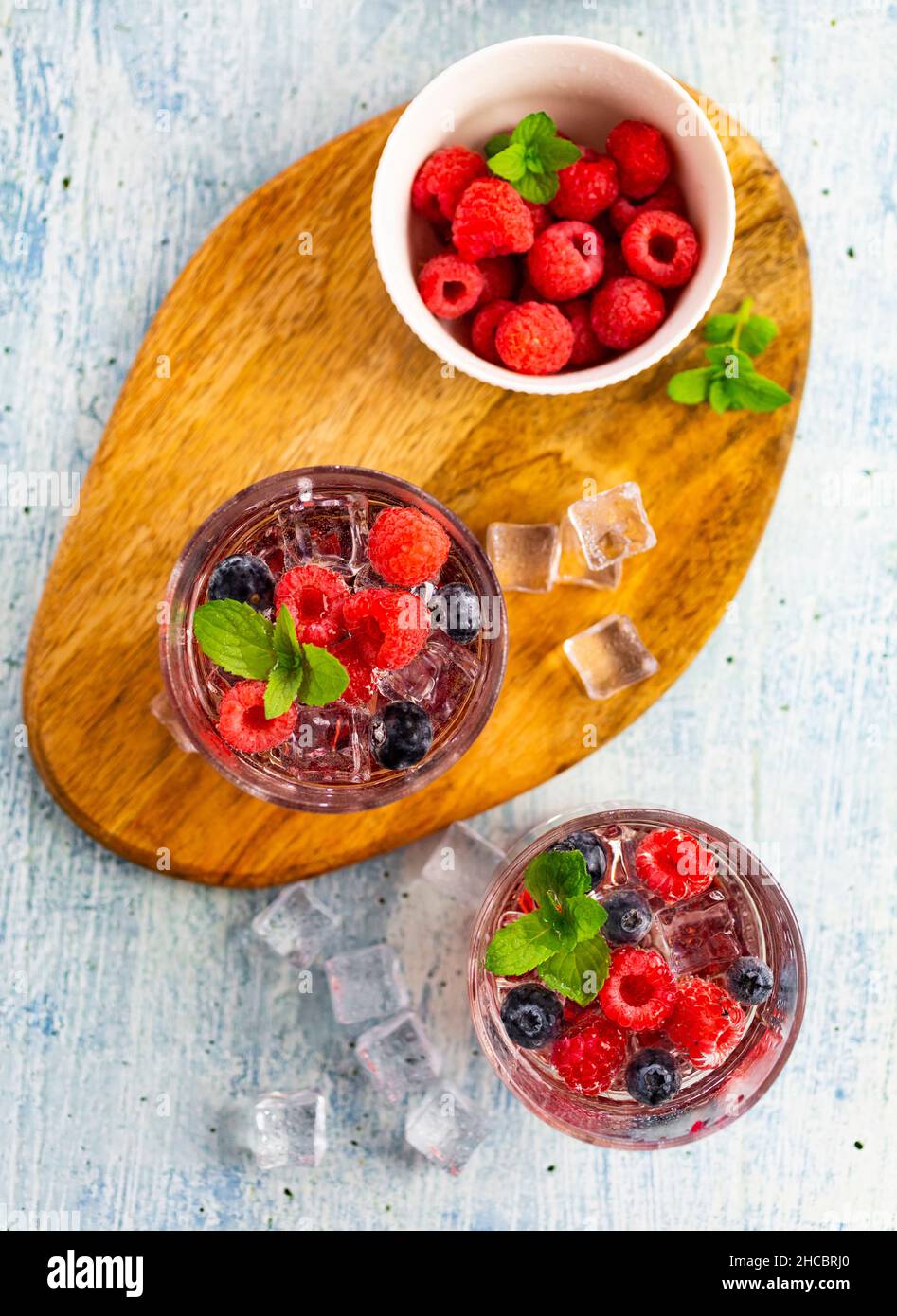 Glas Gin Tonic mit Minze, Eiswürfeln und rohen Beeren Stockfoto