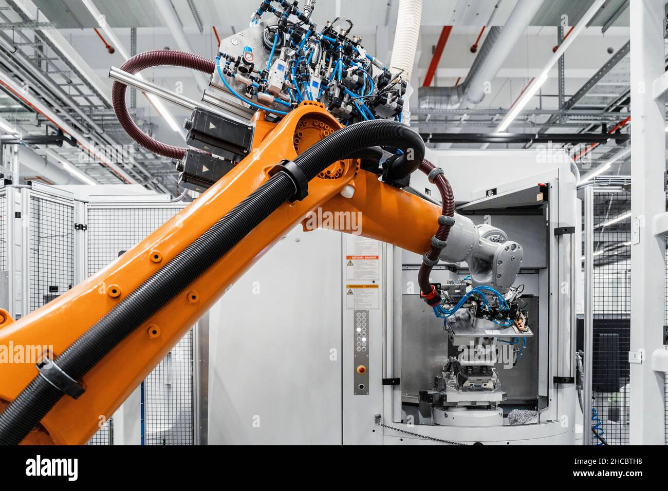 Orangefarbener Roboterarm bei der Elektroindustrie Stockfoto
