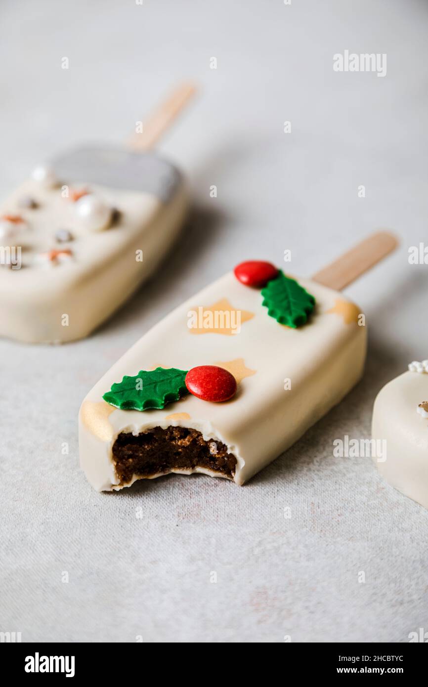 Weihnachtlich dekorierte Cake Pops stapeln sich auf dem Kühlregal Stockfoto