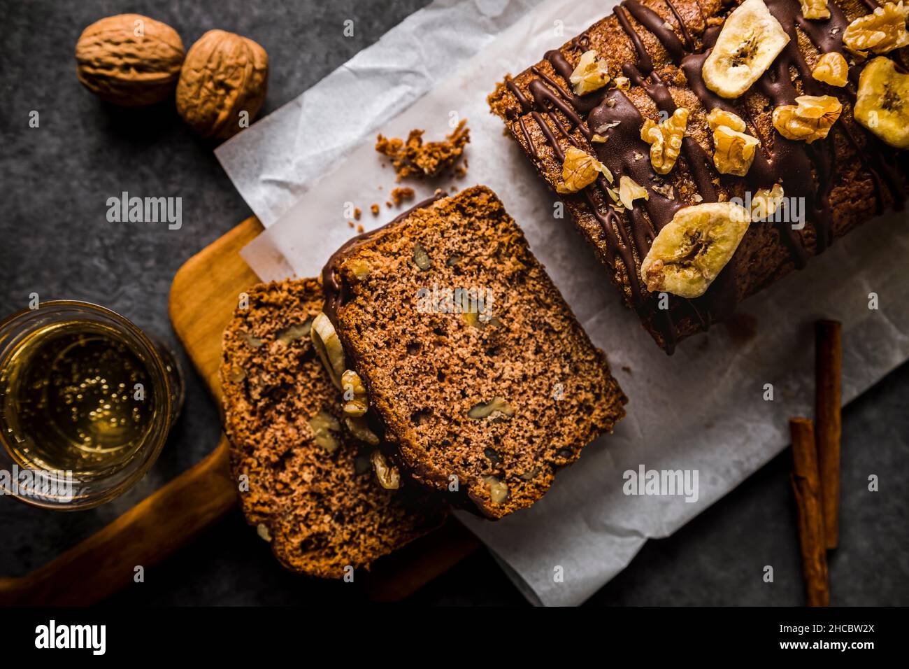 Bananenkuchen mit Walnuss- und Schokoladensauce auf dem Tisch Stockfoto