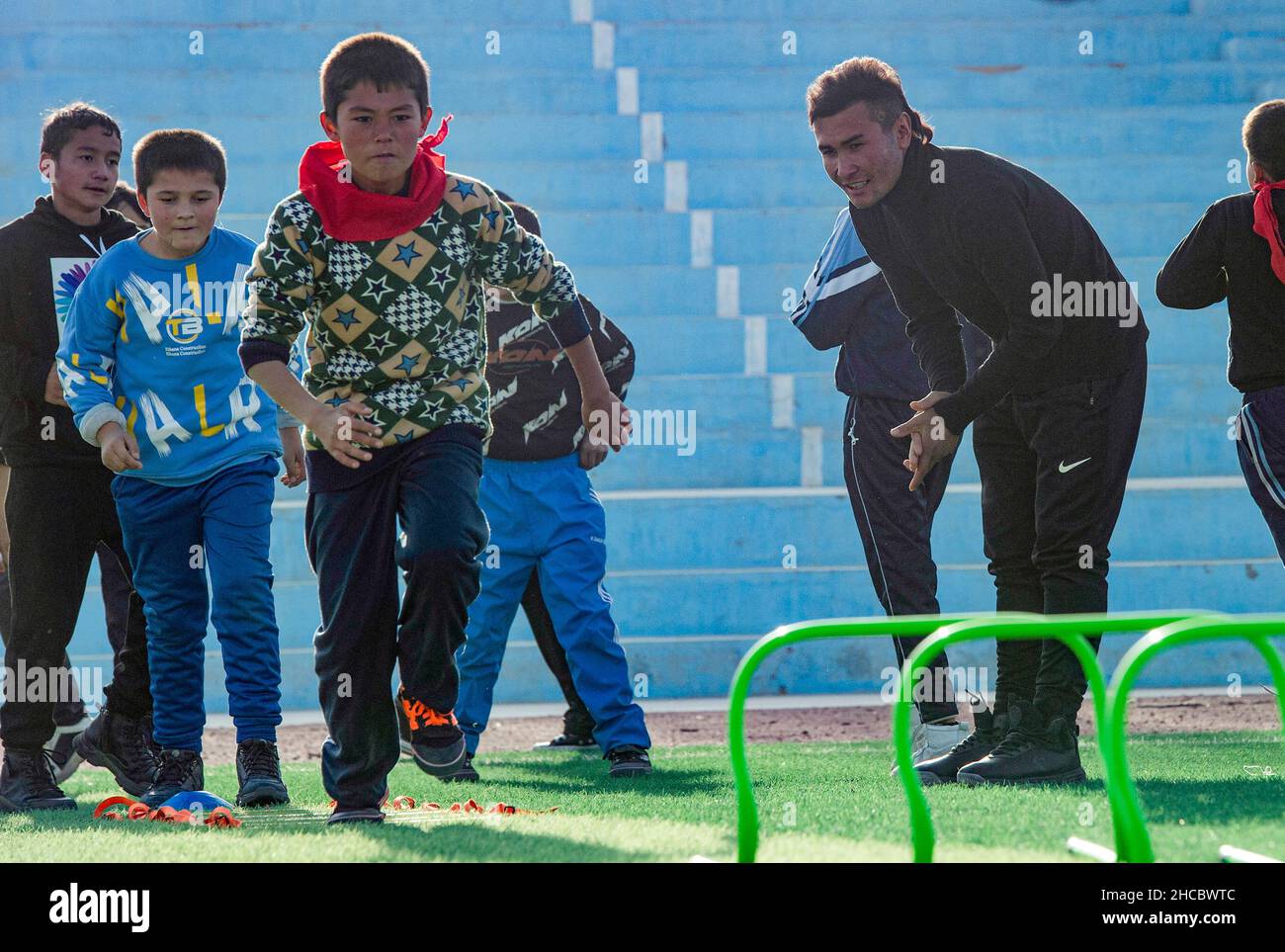(211227) -- URUMQI, 27. Dezember 2021 (Xinhua) -- Nurmemet Sherep unterrichtet Kinder an der zentralen Grundschule der Gemeinde Saybagh im Bezirk Shufu der Präfektur Kashgar, nordwestlich der Autonomen Region Xinjiang, Uygur, 15. November 2021. DAZU: 'Profil: Von Kornfeldern zu Fußballfeldern: Der autodidaktige Xinjiang Fußballstar' (Xinhua/Ma Kai) Stockfoto