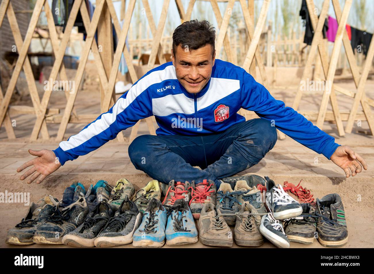 Urumqi, Chinas Autonome Region Xinjiang Uygur. 13th. November 2021. Nurmemet Sherep zeigt seine getragenen Fußballschuhe auf seinem Hof im Bezirk Shufu der Präfektur Kashgar, nordwestlich der Autonomen Region Xinjiang Uygur in China, 13. November 2021. DAZU: 'Profil: Von Kornfeldern zu Fußballfeldern: Der autodidaktige Xinjiang-Fußballstar' Credit: MA Kai/Xinhua/Alamy Live News Stockfoto