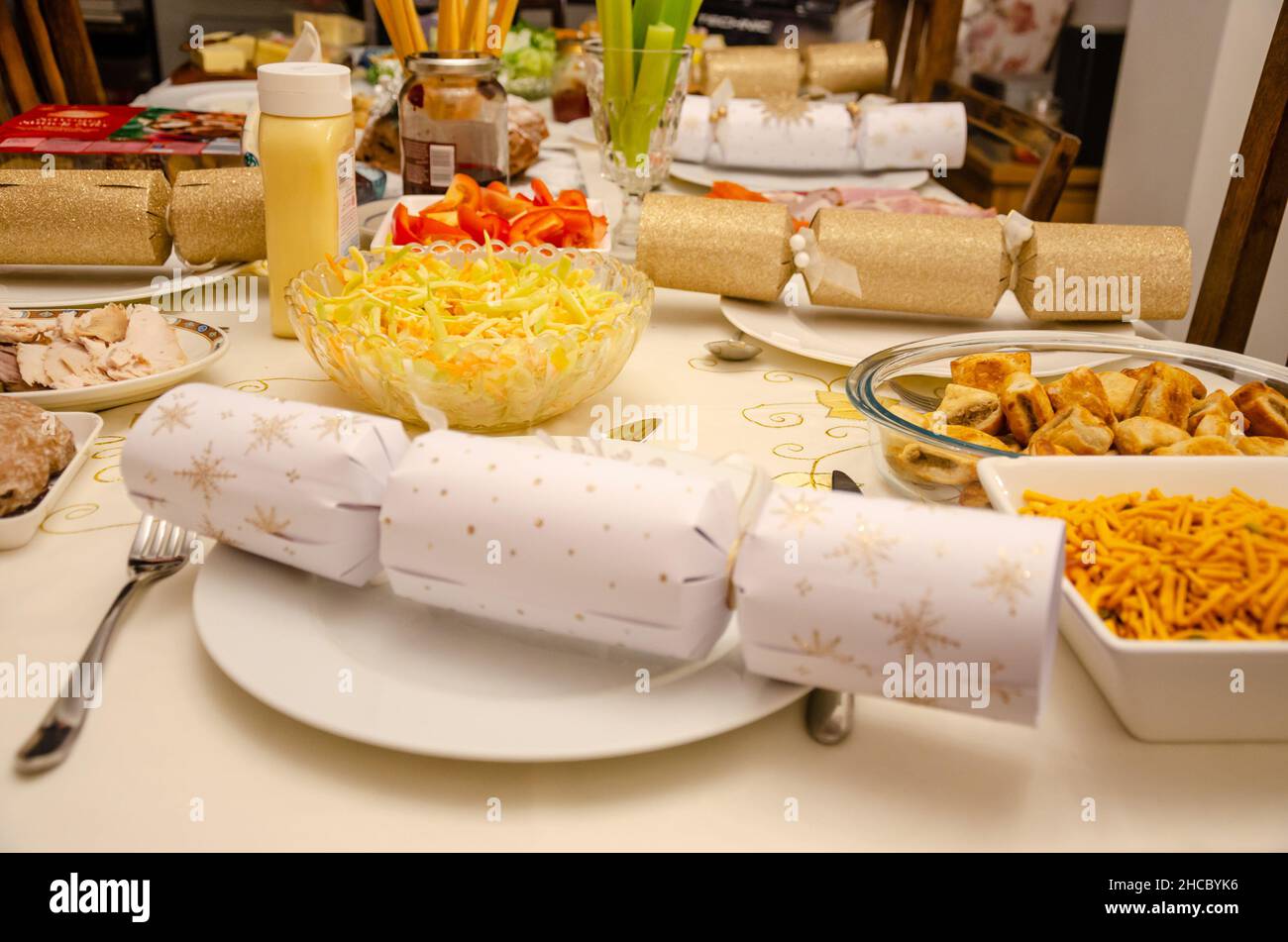 Eine Auswahl an Speisen auf einem Tisch, der für einen Salat zum Weihnachtstee mit festlichen Weihnachtskräckern ausgelegt ist. Stockfoto