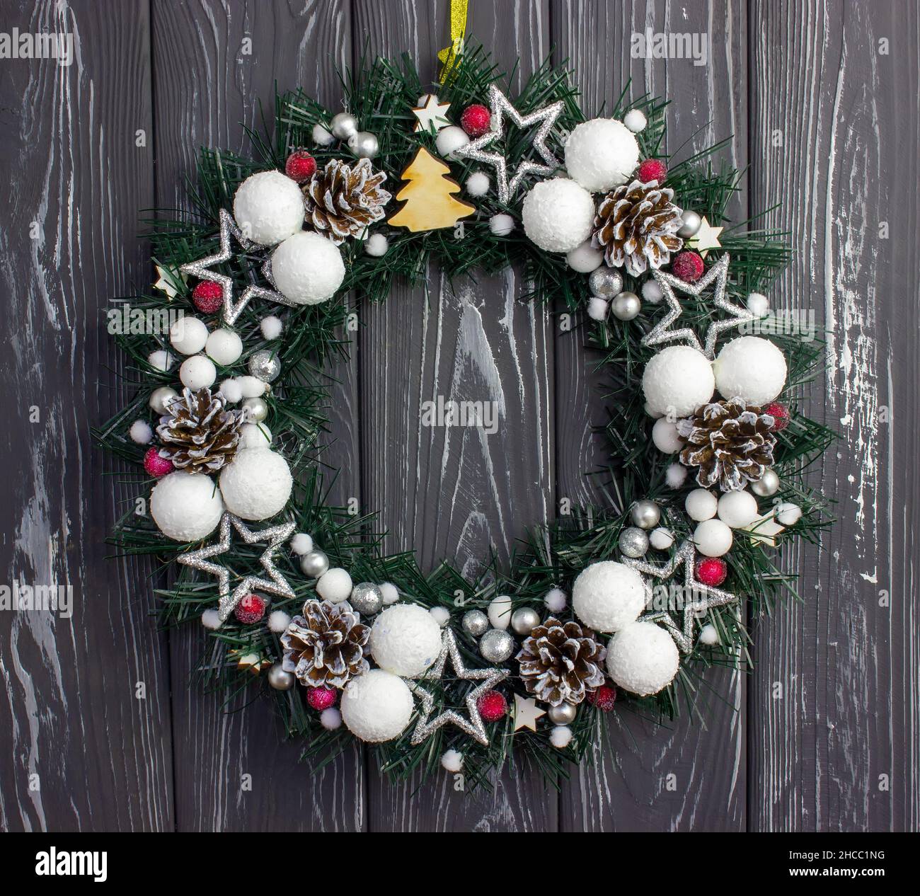 Weihnachtskranz auf grauem Holzhintergrund. Weihnachtsdekoration an der Tür Stockfoto