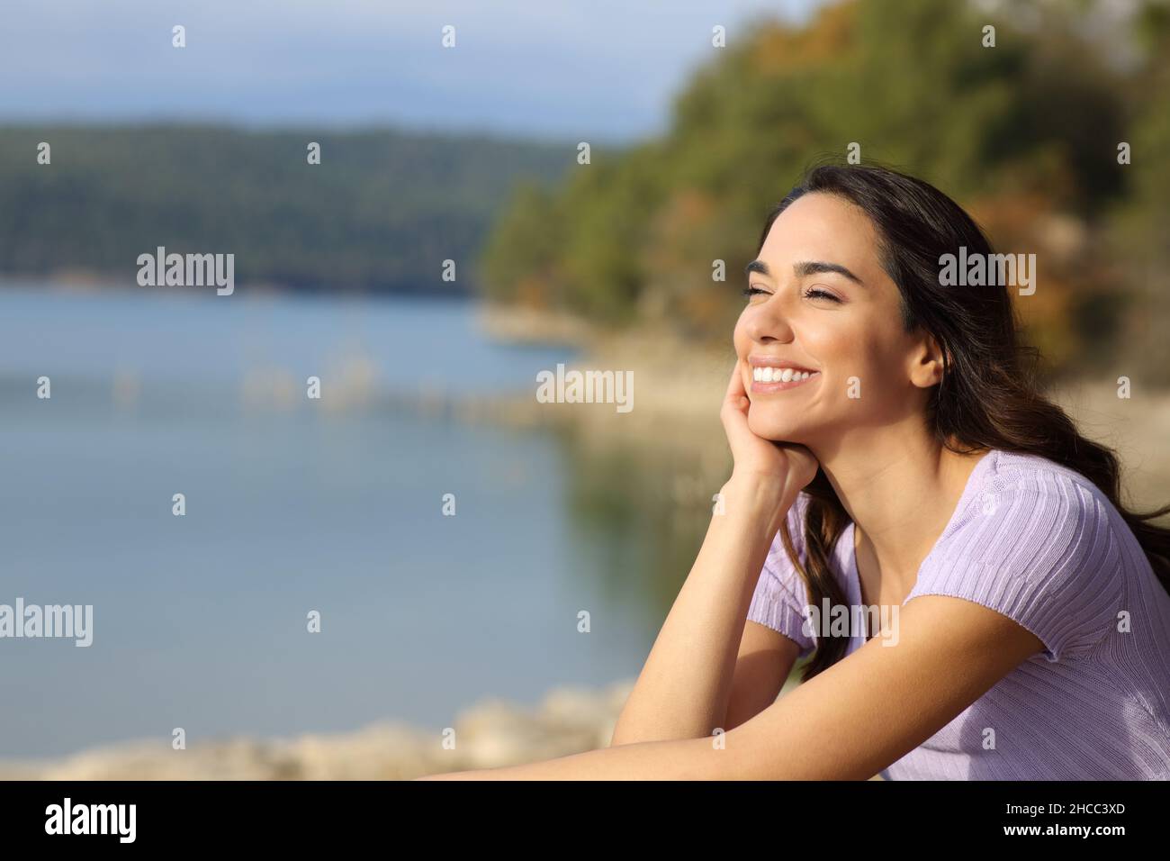 Glückliche Frau entspannt Blick in einem Bergsee betrachten einen sonnigen Tag Stockfoto