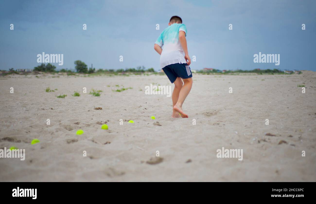 Ein Teenager trainiert auf dem Sand. Sportliche Aktivitäten. Fußarbeit. Stockfoto