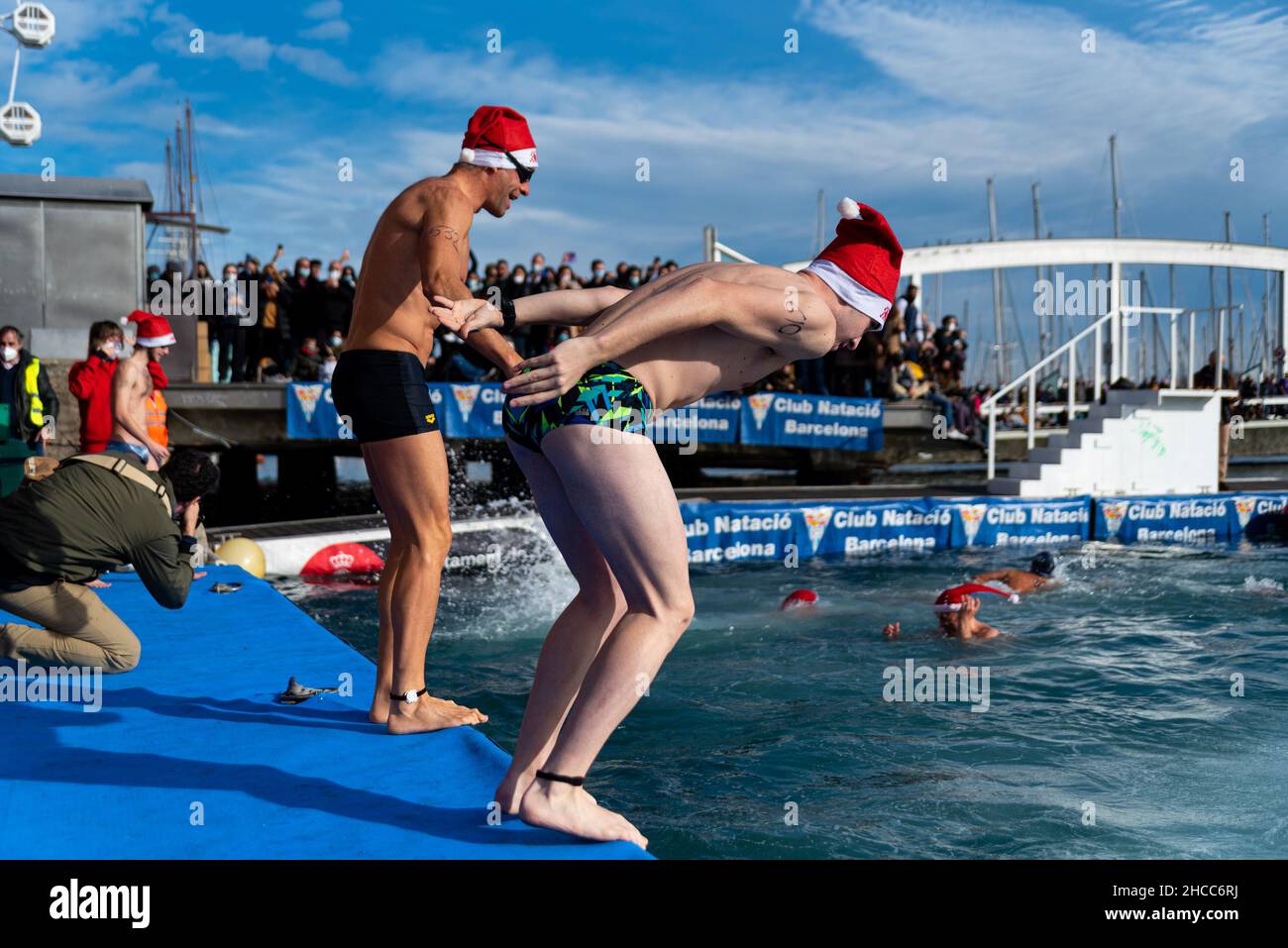 Menschen, die als Weihnachtsmann verkleidet sind, springen am Weihnachtsfest in Barcelon auf den traditionellen „Copa Nadal“, Spaniens ältestem Freiwasser-Schwimmwettbewerb Stockfoto