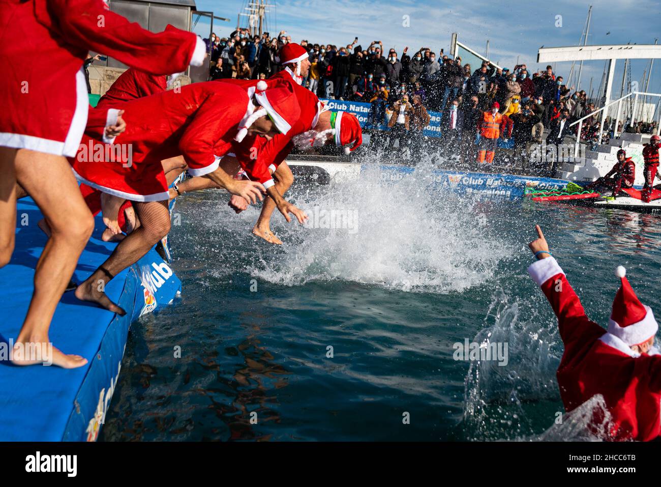 Menschen, die als Weihnachtsmann verkleidet sind, springen am Weihnachtsfest in Barcelon auf den traditionellen „Copa Nadal“, Spaniens ältestem Freiwasser-Schwimmwettbewerb Stockfoto