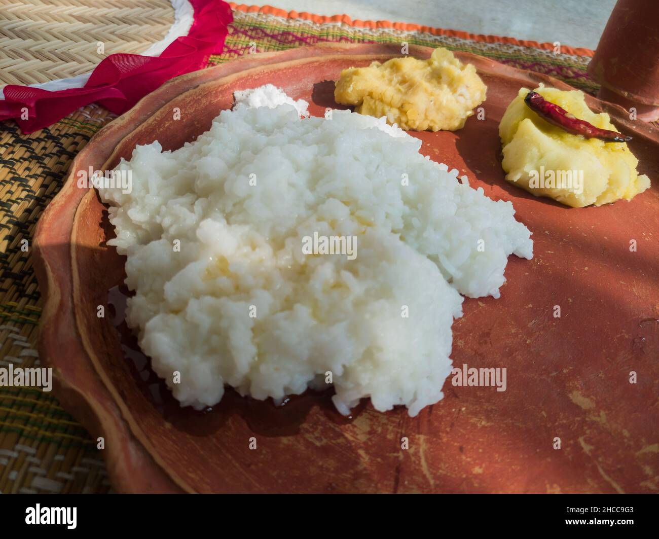 Traditionelle bengalische hausgemachte Thali oder Platte serviert auf Teller aus Ton. Gekochter Reis, Linsen und Kartoffeln. Authentische indische bengalische lokale Kultur Stockfoto