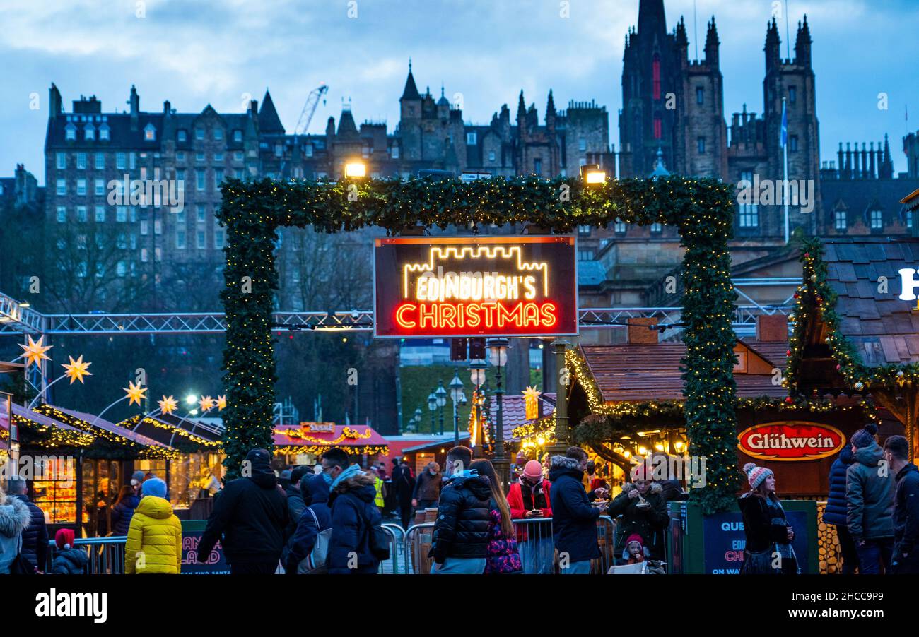 Edinburgh, Schottland, Großbritannien. 27th. Dezember 2021. Der Weihnachtsmarkt in Edinburgh wurde am zweiten Weihnachtsfeiertag mit neuen Regeln wiedereröffnet, um die Verbreitung der Omicron-Variante von Covid-19 zu verhindern, insbesondere wird nur ein Eingang verwendet, um die Anzahl zu heben. Besucher werden gebeten, vor dem Besuch einen seitlichen Durchflusstest durchzuführen. Tragen Sie eine Maske, halten Sie sich etwa 2m auseinander und folgen Sie den Schildern in den Gärten der East Princes Street. Iain Masterton/Alamy Live News. Stockfoto