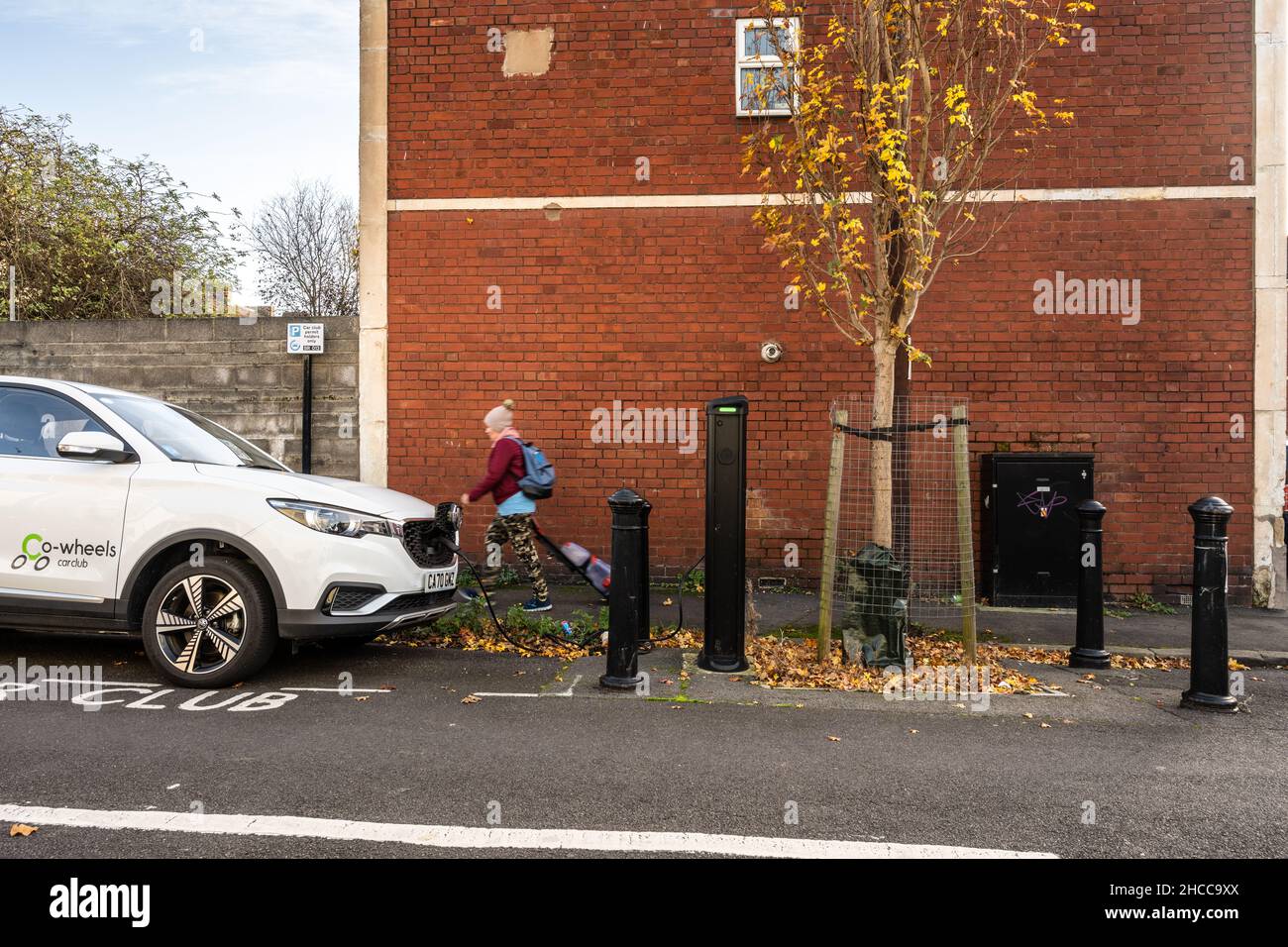 Ein Car Club mietet ein Auto an einer Ladestation für Elektroautos auf der Straße in einer Wohnstraße in Bristol. Stockfoto