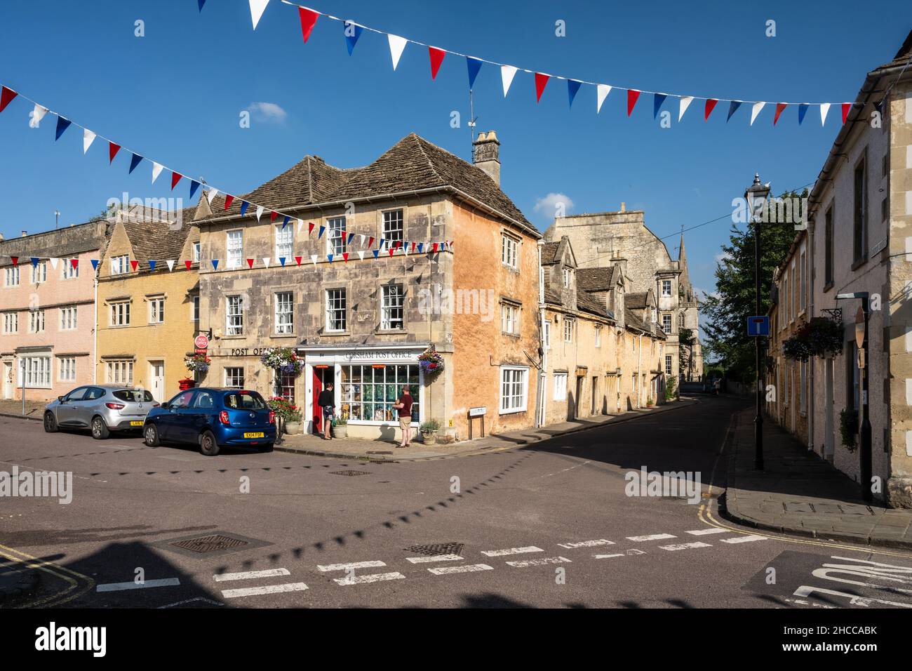 In der traditionellen High Street in der Marktstadt Corsham, Wiltshire, stehen die Käufer vor einem Postamt an. Stockfoto