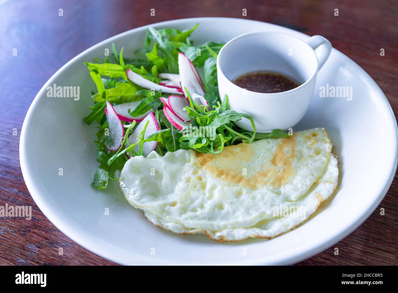 Gebratenes Eiweiß mit Salat und Sesam-Balsamico-Dressing gesundes Frühstück Stockfoto