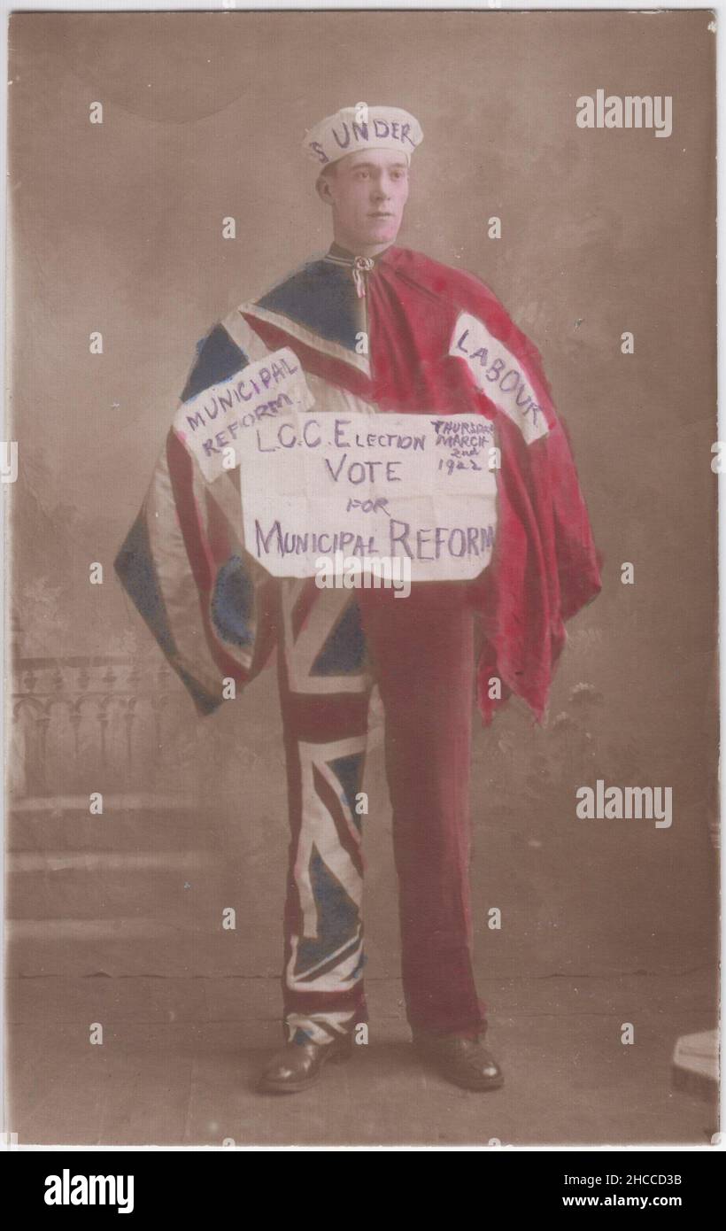 'LCC Election Vote for Municipal Reform', 2. März 1922: Getöntes Kampagnenfoto für die Wahlen im Londoner County Council 1922. Es zeigt einen Mann mit einem handgeschriebenen Slogan, der in einem zweigeteilten Kostüm gekleidet ist - eine Hälfte besteht aus Unionsflaggen mit der Aufschrift „Stadtreform“, die andere ist rot mit der Aufschrift „Arbeit“ gefärbt Stockfoto