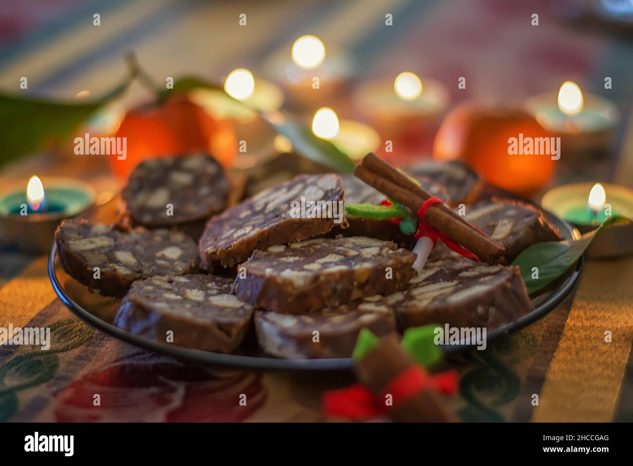 Weihnachtsplätzchen. Stapel von Chocolate Chip Cookies, Zimt, Anise, verschiedene Weihnachtsdekorationen und brennende Kerzen. Selektiver Fokus. Stockfoto