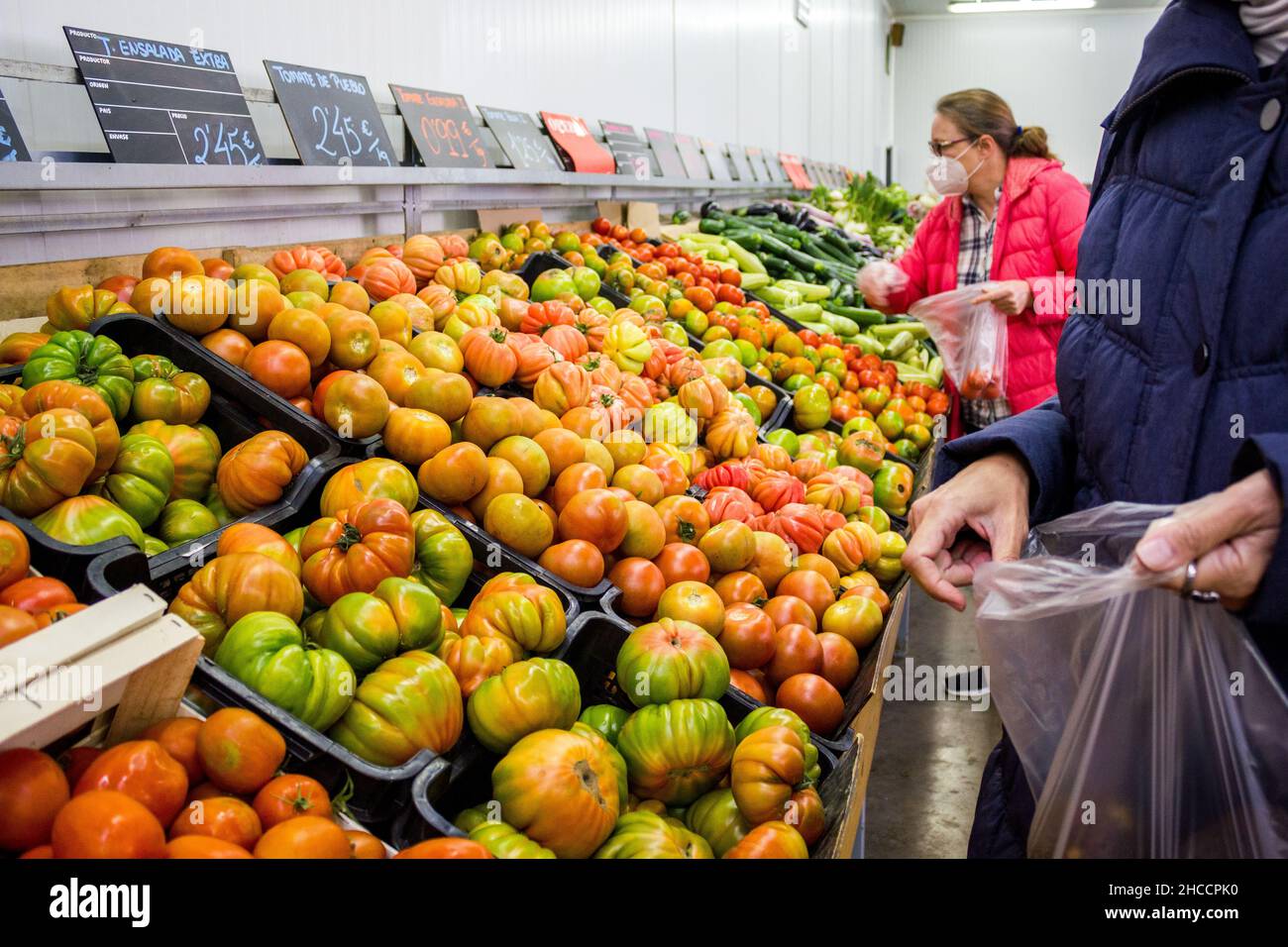 Valencia, Spanien; 26th. märz 2021: Menschen kaufen während der Neuen Normalität Obst und Gemüse in einem Obstladen Stockfoto