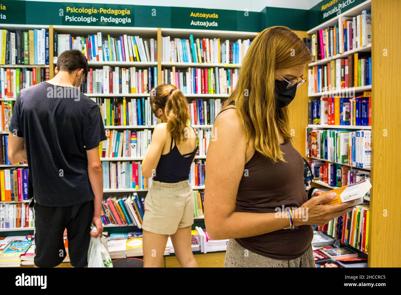 Valencia, Spanien; 6th. juli 2021: Maskierte Menschen in einem Buchladen während der Neuen Normalität Stockfoto